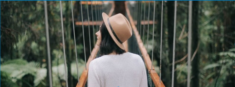 Person crossing a wooden bridge surrounded by forest, symbolizing the journey amid anxiety, ADHD, and inner turmoil.